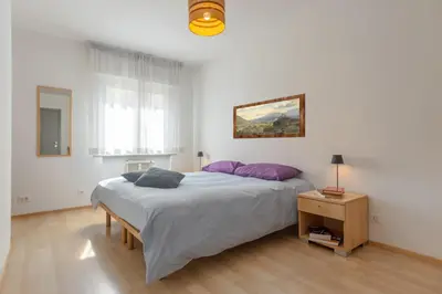 a bedroom with a large bed with purple pillows at Dolomiapartments - Appartamento Centrale in Predazzo