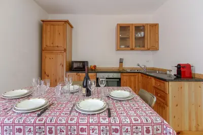 a table with glasses and plates on it in a kitchen at Dolomiapartments - Appartamento Centrale in Predazzo