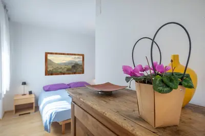 a bedroom with a table with a potted plant on it at Dolomiapartments - Appartamento Centrale in Predazzo