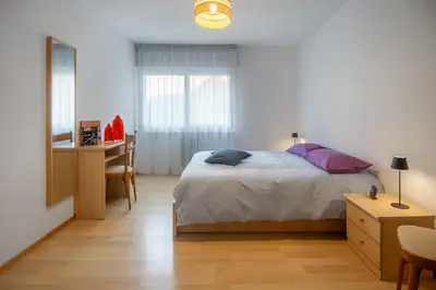 a bedroom with a bed and a table and a desk at Dolomiapartments - Appartamento Centrale in Predazzo
