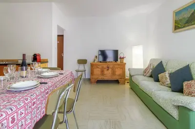 a living room with a table and a couch at Dolomiapartments - Appartamento Centrale in Predazzo