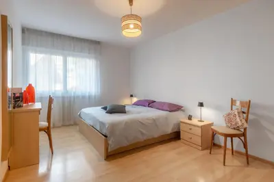 a bedroom with a bed and a table and a desk at Dolomiapartments - Appartamento Centrale in Predazzo
