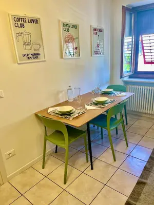 a dining room table with green chairs and a table and chairsktop at Appartamento verde in Cloz