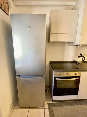 a kitchen with a stainless steel refrigerator and a microwave at Appartamento verde in Cloz