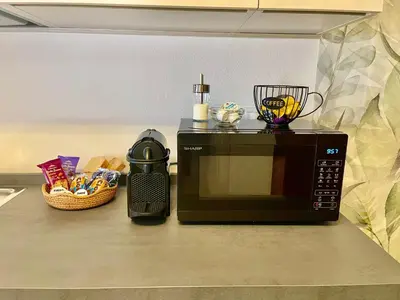 a microwave sitting on a counter next to a basket of food at Appartamento verde in Cloz
