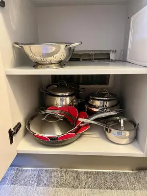 a shelf with pots and pans and a bowl at Appartamento verde in Cloz