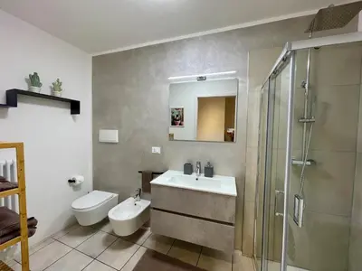 a bathroom with a sink and a toilet and a shower at Appartamento verde in Cloz