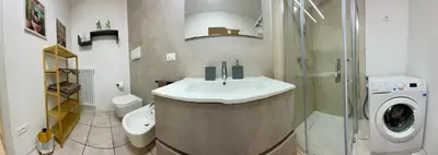 a bathroom with a sink and a washing machine at Appartamento verde in Cloz