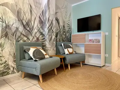 a living room with two chairs and a flat screen tv at Appartamento verde in Cloz