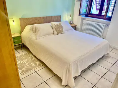 a bedroom with a large bed with white sheets and pillows at Appartamento verde in Cloz
