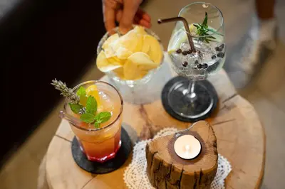 a wooden table with two cocktails and a candle on it at Hotel Ortler in Castelrotto