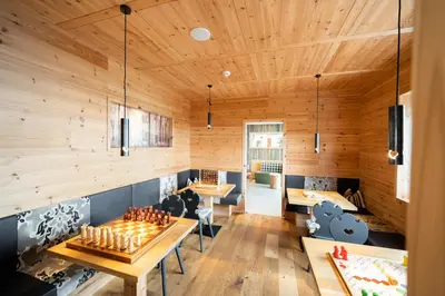a restaurant with wooden walls and wooden tables and benches at Hotel Ortler in Castelrotto