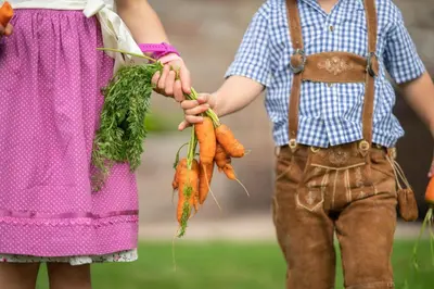 a boy and a girl holding carrots in their hands at Hotel Ortler in Castelrotto