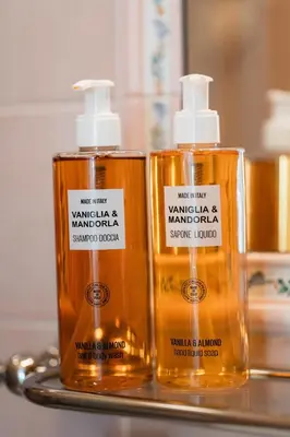 two bottles of soap sitting on a bathroom counter at Hotel Oasi in Cortina dʼAmpezzo