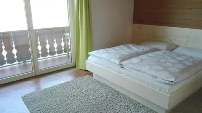 a bedroom with a bed and a balcony at Digart apartment in Ortisei