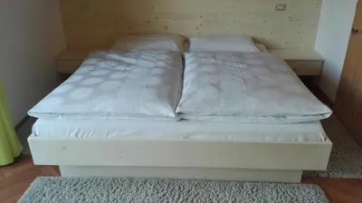 a bed with two white pillows on it in a room at Digart apartment in Ortisei