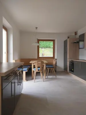 a kitchen with a table and chairs in a room at Digart apartment in Ortisei