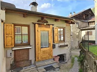 an old house with wooden doors and windows at 1500-year-old El Molin Cottage in the heart of Moena in Moena