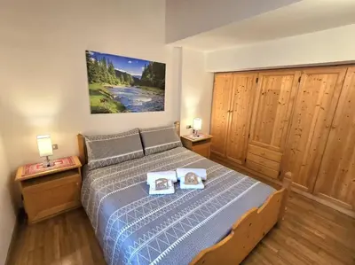 a bedroom with a bed with two books on it at 1500-year-old El Molin Cottage in the heart of Moena in Moena