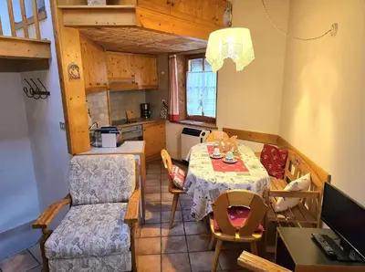 a kitchen and dining room with a table and chairs at 1500-year-old El Molin Cottage in the heart of Moena in Moena