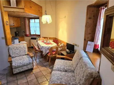 a living room with a couch and a table at 1500-year-old El Molin Cottage in the heart of Moena in Moena