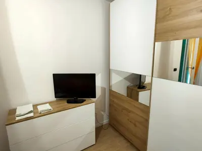 a room with a tv on a dresser with a mirror at La casa di Nicole in Romeno