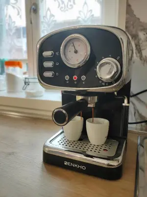 a coffee maker with two cups on a table at La casa di Nicole in Romeno