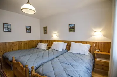 two twin beds in a room with wooden walls at Villetta Chiave in Chiave