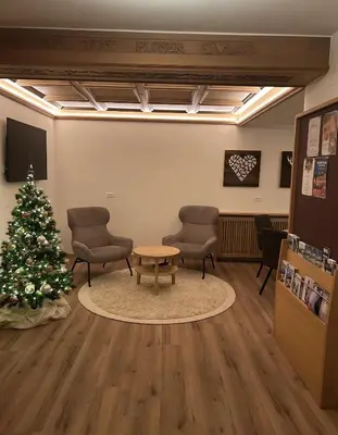 a waiting room with a christmas tree and chairs at Pension Grohmann in Santa Cristina in Val Gardena