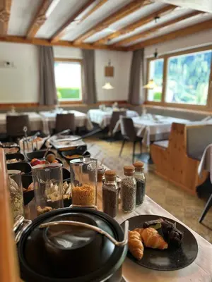 a dining room with a table with a plate of food at Pension Grohmann in Santa Cristina in Val Gardena