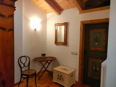a room with a table and a chair and a door at Appartamento Maso Tati in Predazzo