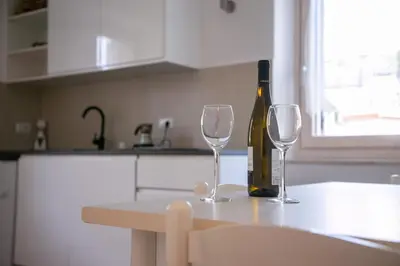 a bottle of wine and two wine glasses on a kitchen counter at Casa Maia in Sanzeno