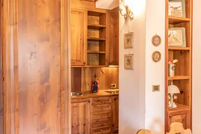 a kitchen with wooden cabinets and a counter top at Casa Crignes, residenziale a due passi dal centro in Cortina dʼAmpezzo