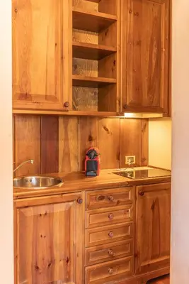 a kitchen with wooden cabinets and a sink at Casa Crignes, residenziale a due passi dal centro in Cortina dʼAmpezzo
