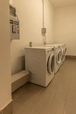 a laundry room with three washing machines in a room at Casa Crignes, residenziale a due passi dal centro in Cortina dʼAmpezzo
