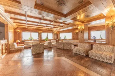 a large room with chairs and tables and wooden ceilings at Casa Crignes, residenziale a due passi dal centro in Cortina dʼAmpezzo