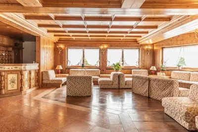 a large room with chairs and tables and windows at Casa Crignes, residenziale a due passi dal centro in Cortina dʼAmpezzo