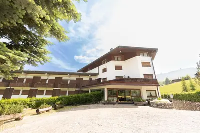 a large white building with a patio in front of it at Casa Crignes, residenziale a due passi dal centro in Cortina dʼAmpezzo