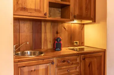 a kitchen with wooden cabinets and a sink at Casa Crignes, residenziale a due passi dal centro in Cortina dʼAmpezzo