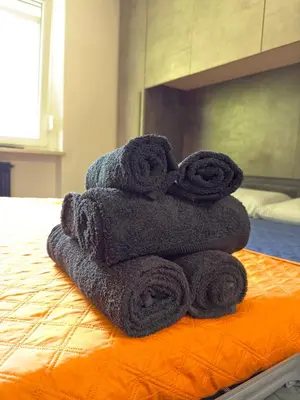 a pile of towels sitting on top of a bed at Regina del bosco in Ronzone