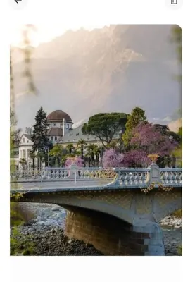 a bridge over a river with houses and trees at Merano appartamento in Merano