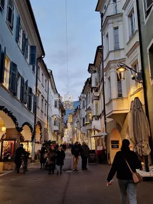 a group of people walking down a street with buildings at Merano appartamento in Merano