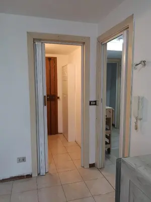 an empty hallway with two doors and a tile floor at Nido del Melo in Cles