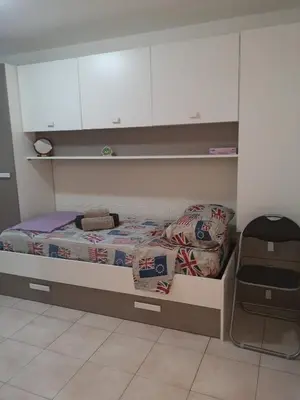 a small bedroom with a bed and white cabinets at Nido del Melo in Cles