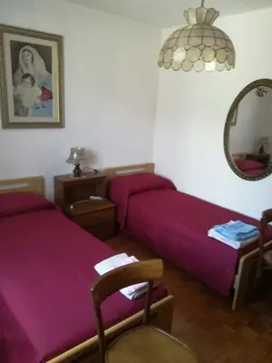 a bedroom with two beds and a mirror and a chair at Casa Alice in Mezzano