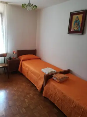 two beds in a room with orange sheets at Casa Alice in Mezzano