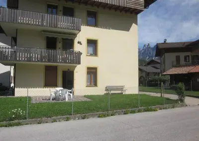 a building with a table and a bench in front of it at Casa Dolomite in Mezzano