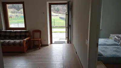 a room with a door open to a room with a couch at Casa Dolomite in Mezzano
