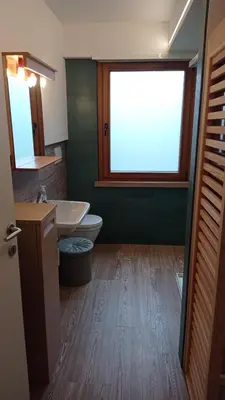 a bathroom with a sink and a toilet and a window at Casa Dolomite in Mezzano