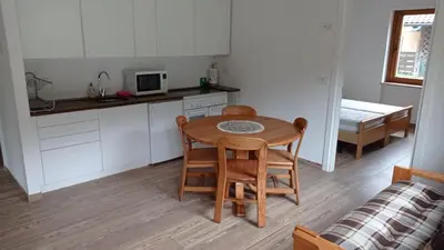 a kitchen with a table and chairs in a room at Casa Dolomite in Mezzano